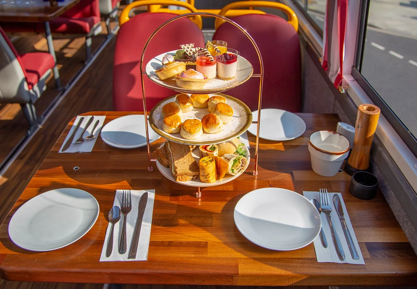Tiered afternoon tea stand beside a London bus window